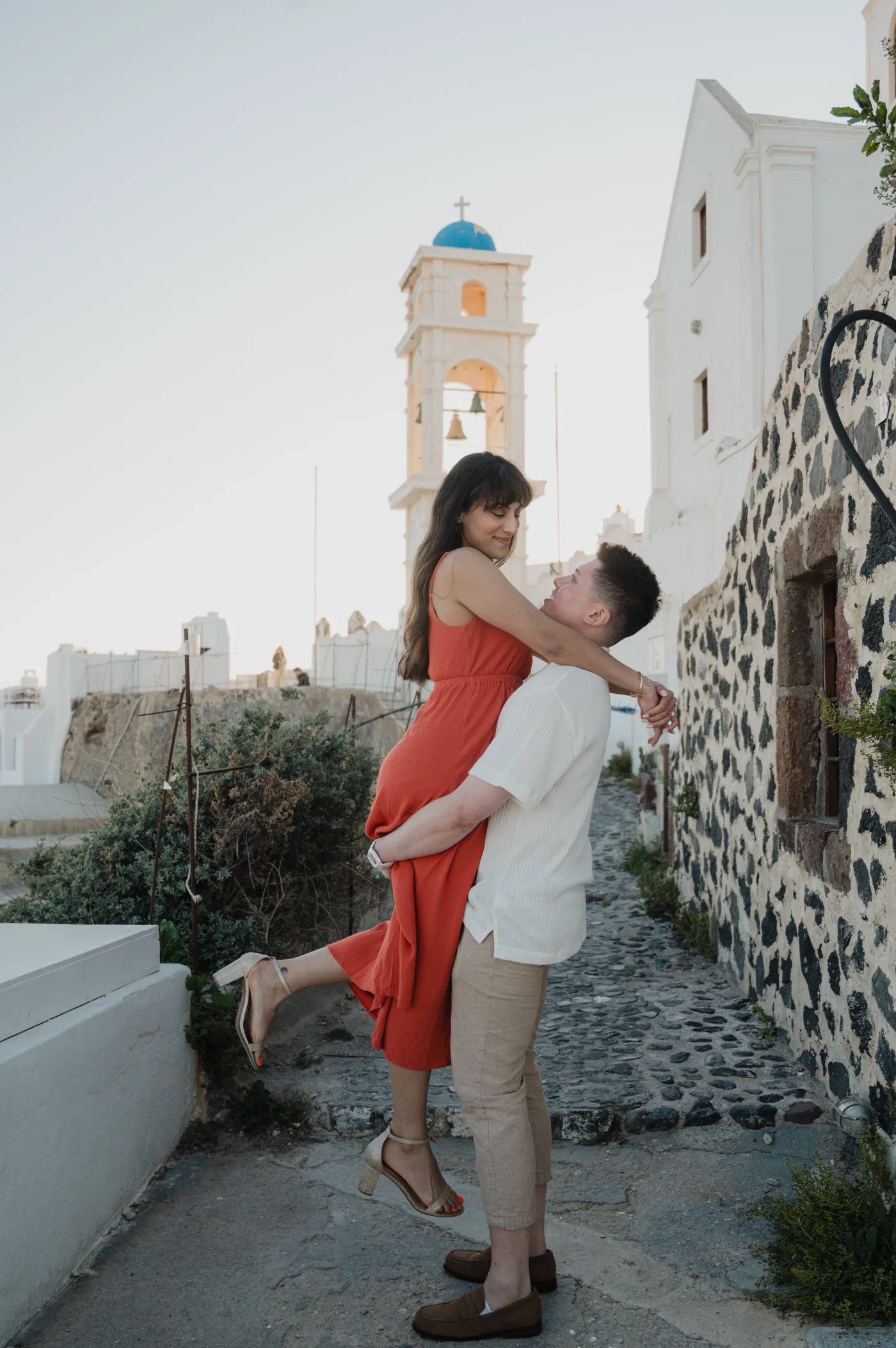 Erin and Fredrik holding each other on a whitewashed stone lane after their engagement